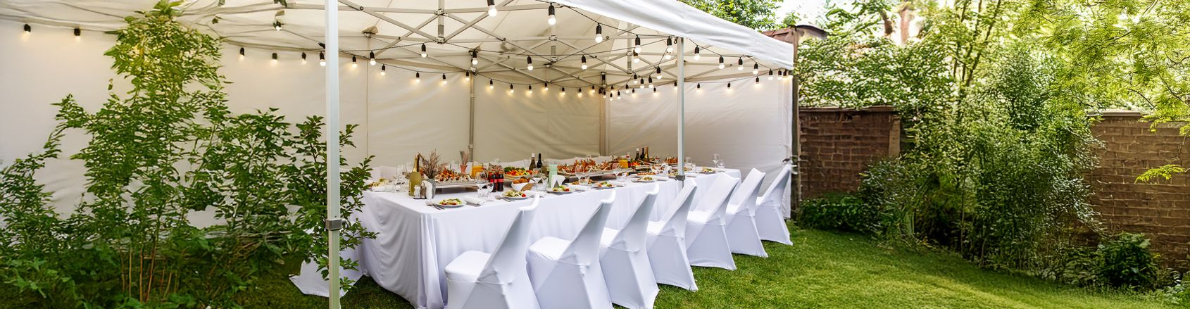 Witte TecTronic feesttent met sfeervolle verlichting en stoelhoezen