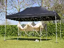 Zwarte vouwtent opgezet en een beige gevouwen vouwtent